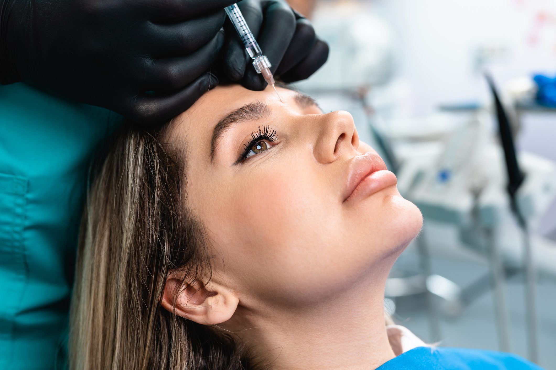 Woman receiving a cosmetic facial injection at a clinic.