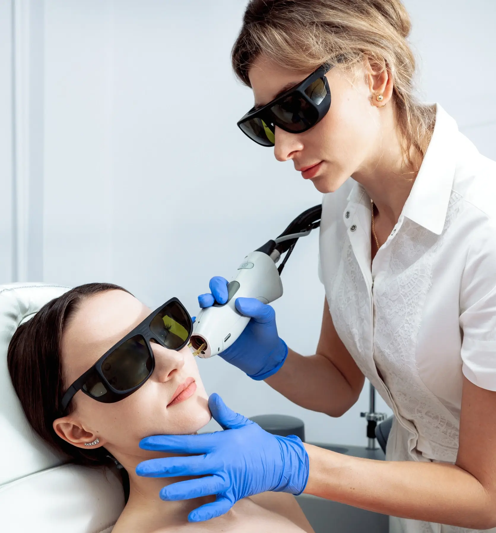 Clinician using handheld laser on patient's cheek