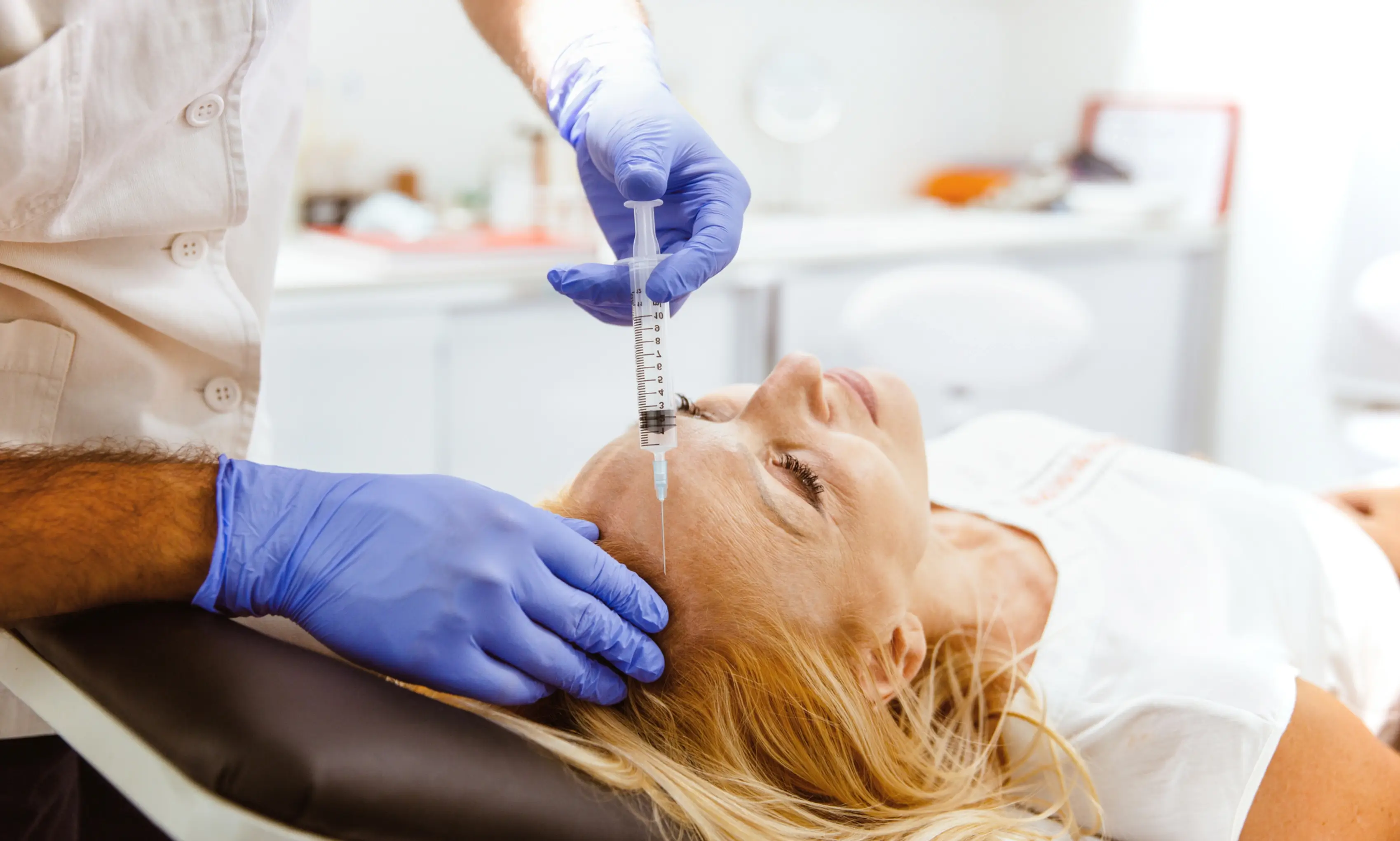 Clinician administering cosmetic injection to forehead